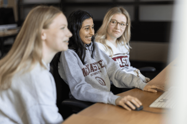 Three students in the media lab working at computers.